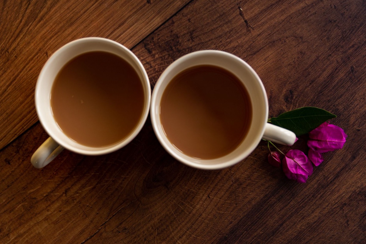 Zwei Kaffeetassen auf einem Holztisch.