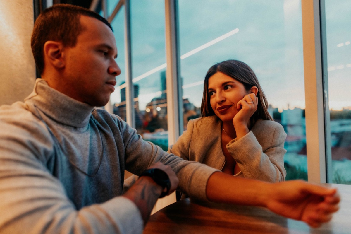Contacto visual intenso y sonrisas entre dos personas durante una cita.