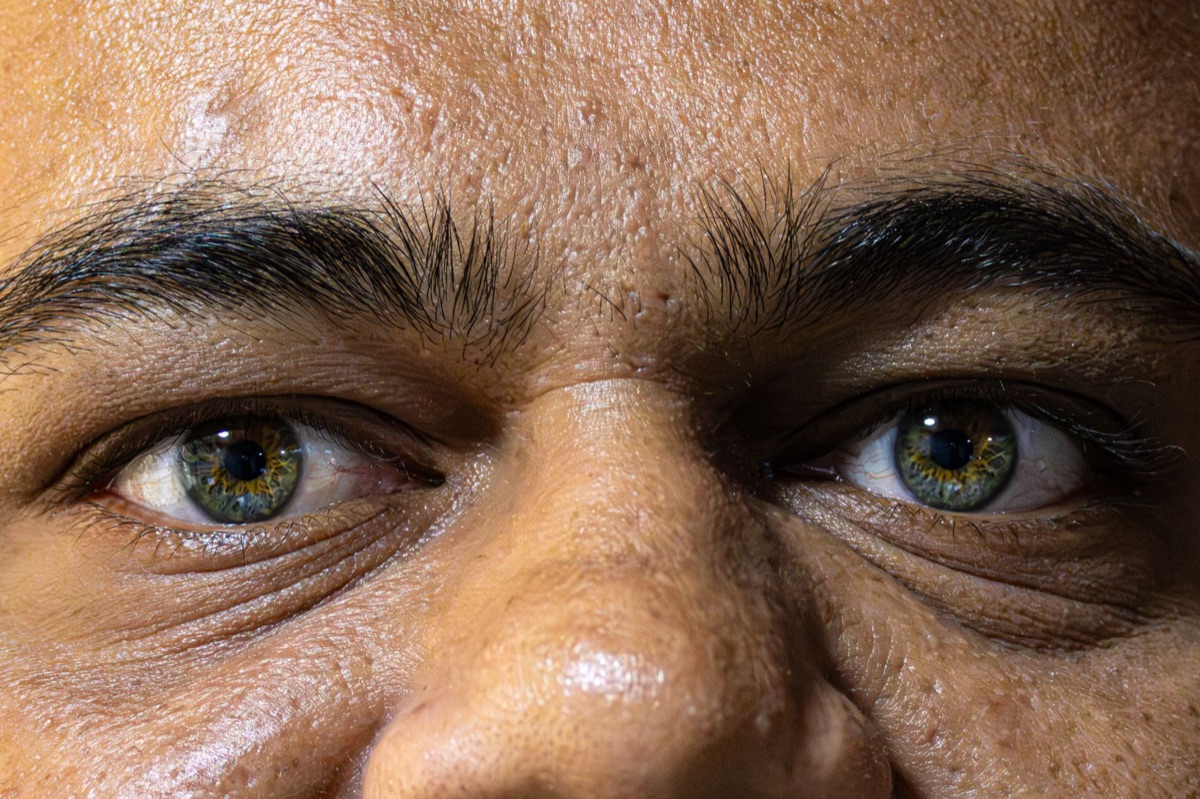 Close-up de um olhar atento e sorriso sutil.