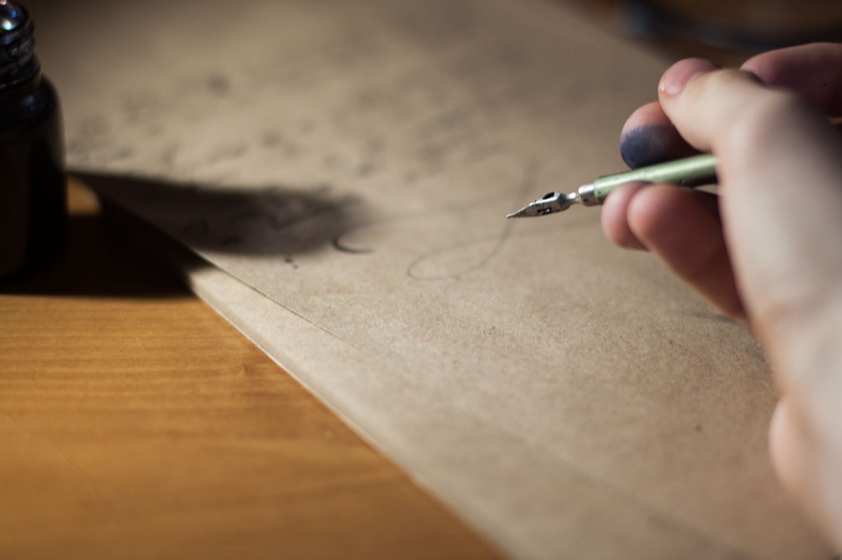 Une lettre manuscrite avec un stylo plume sur du papier ancien.