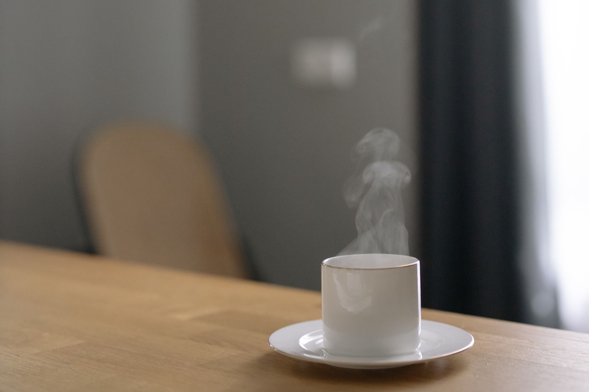 Deux tasses de café fumantes sur une table en bois.