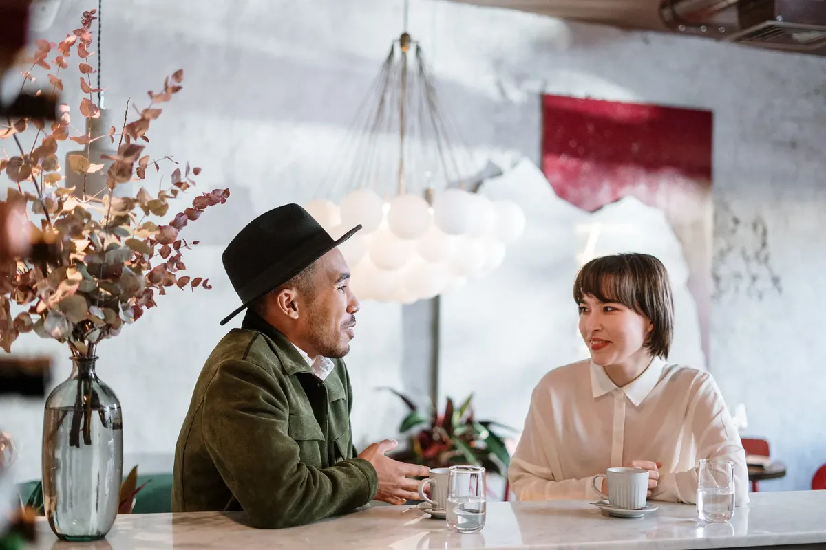 A candid moment capturing a friendly chat in a stylish café setting. Elegant and warm.