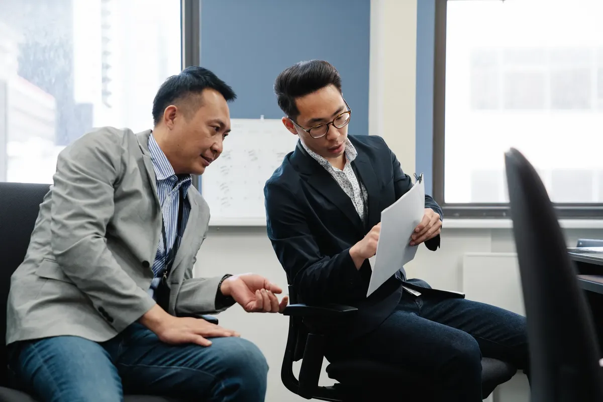 兩名專業人士在現代辦公室環境中進行合作討論。